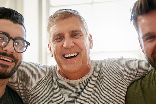 Stock photo of two sons laughing with their dad