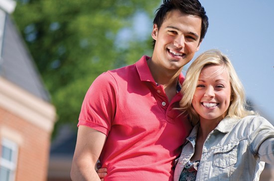 Stock image of a couple holding keys to their new house