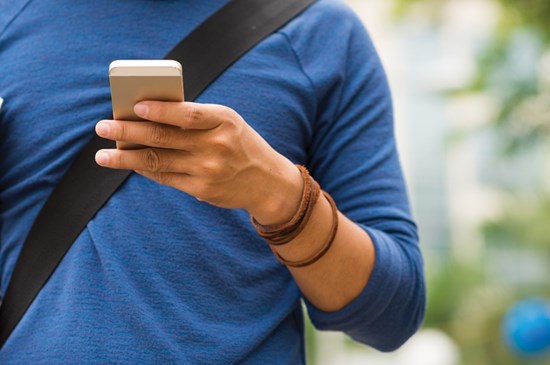 Stock photo depicting mobile banking with a coffee in hand