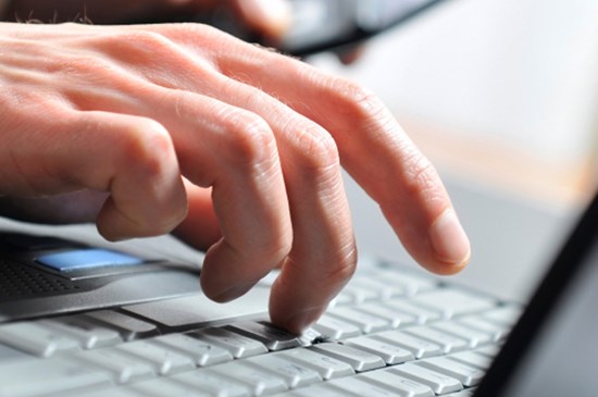 Stock photo depicting hands on a keyboard.