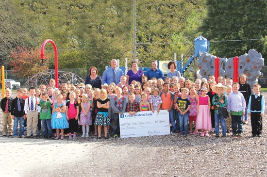 Displaying a donated check from Great Western Bank to go towards playground equipment