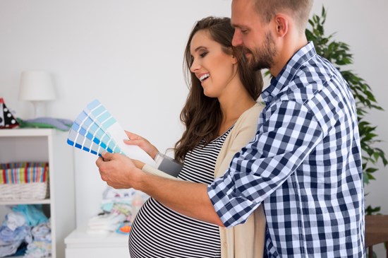 Stock photo of a couple choosing paint colors for a nursery