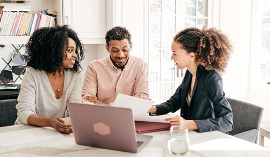 Stock photo of a mortgage officer meeting with two clients