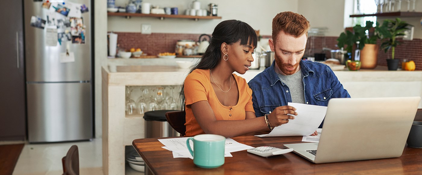 Image of  a young couple researching financing options at a laptop. 