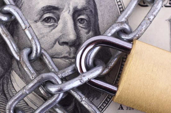 Stock image of a dollar bill and a lock. Be weary of coronavirus related scams.