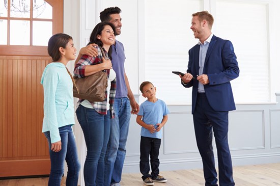 Stock image a family touring a new house with a realtor